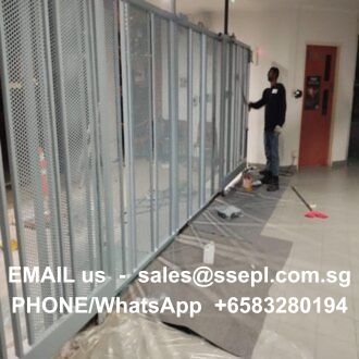 Worker installing metal-framed glass partitions in a hallway under construction; contact info overlaid: sales@ssepl.com.sg and +6583280194.