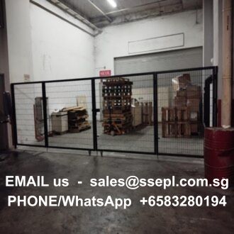 Warehouse behind a black metal gate with pallets and boxes; information overlaid shows an email address and a WhatsApp number for contact.