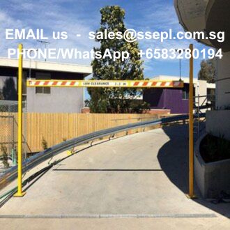 Driveway barrier gate blocking a sloped entrance with a wooden fence and blue sky; white text overlay shows contact email and phone number.