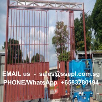 Red metal gate frame at an outdoor construction site with a blue lift and tarp; white overlay text reads: 'EMAIL us – sales@ssepl.com.sg' and 'PHONE/WhatsApp +6583280194'