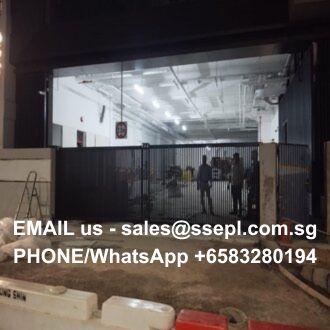 Industrial facility behind a black gate at night; white overlay text shows contact info: 'EMAIL us - sales@ssepl.com.sg PHONE/WhatsApp +65 83280194'
