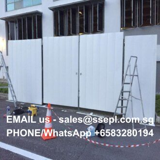 Construction site with white portable wall panels, ladders, orange cones, and red/white caution tape; bottom text shows contact email sales@ssepl.com.sg and phone +65 8328 0194.