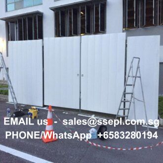 Construction site with white fence panels, ladders, and cones; contact info on the fence reads: EMAIL us sales@ssepl.com.sg, PHONE/WhatsApp +6583280194.